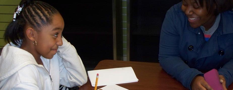 student assisting a child with homework